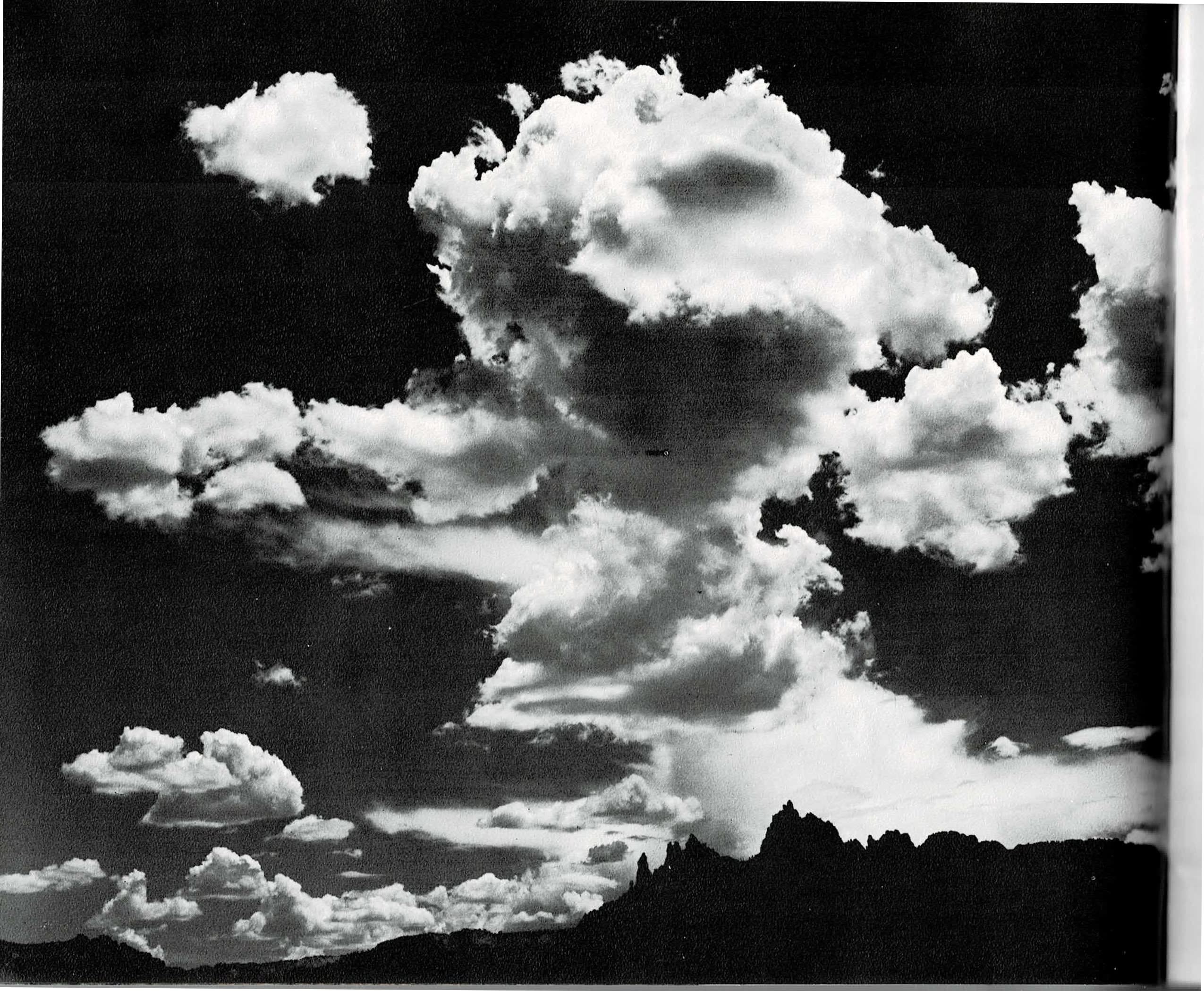 A three-panel spread: at left, a full-bleed black and white photograph of towering cumulus clouds building over the dark silhouette of Eagle Crags; in the center, a text column describing color and light in the Finger Canyons in almost musical terms; at right, a color photograph of an autumn stream in the Kolob, yellow and orange cottonwood leaves overhanging a still pool beside a large boulder.
