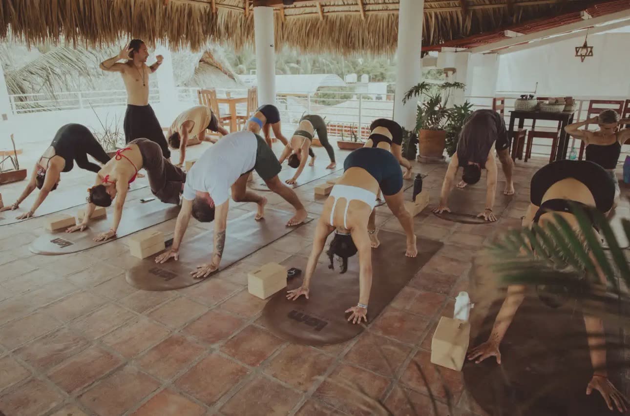 Yogaklasse im herabschauenden Hund unter der Palapa von Le Studio Mak Puerto Escondido
