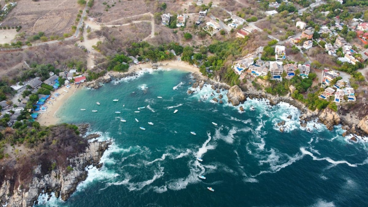 Aerial view of the ocean and the town of Puerto Escondido, where Playa Coral hides at the end of Bacocho