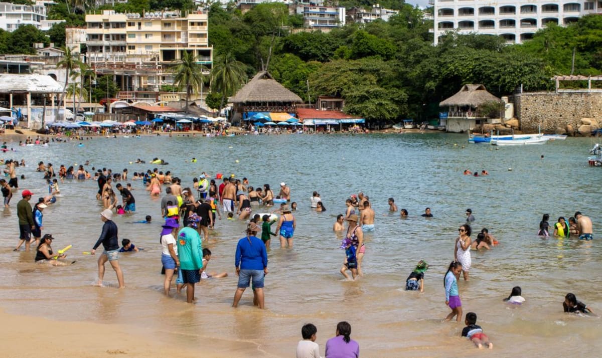 Crowded beach in Mexico during a holiday weekend, similar to what Puerto Escondido sees at peak puentes