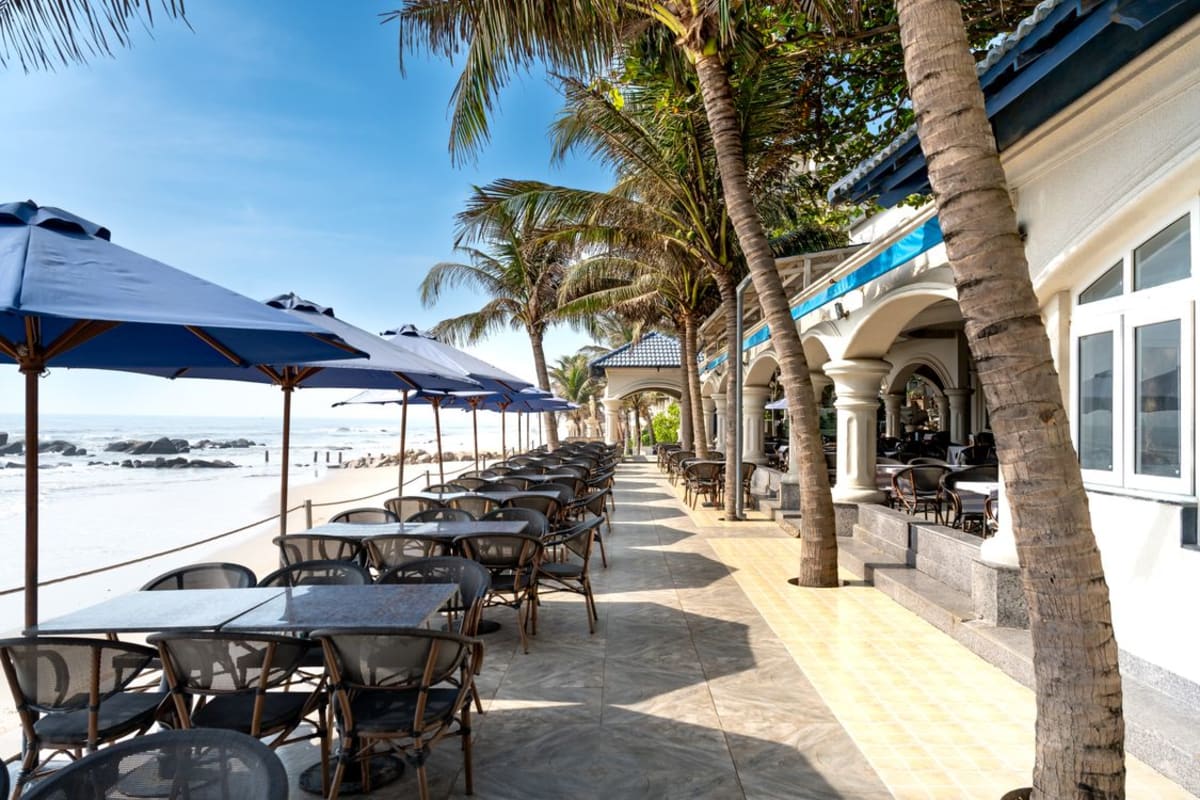 Beachfront patio with tables and palm trees overlooking the Pacific near Puerto Escondido seafood restaurants