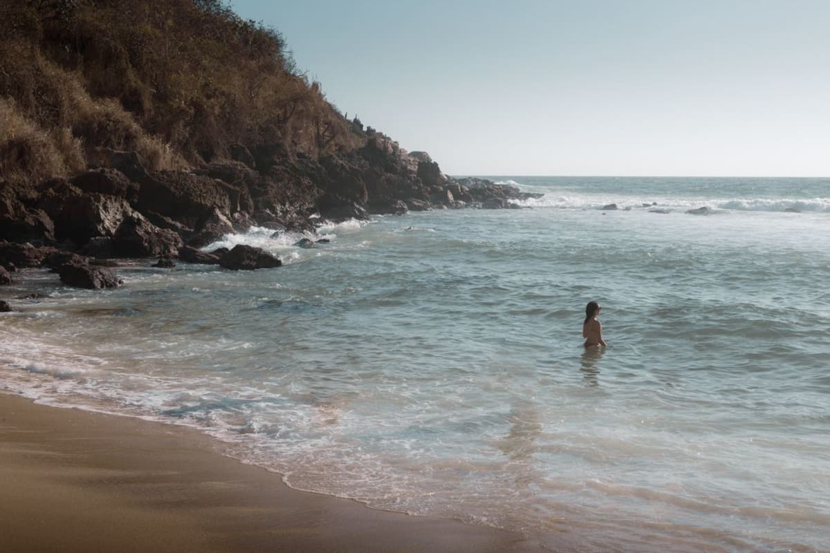Swimmer in calm ocean water near a quiet beach in Oaxaca, similar to San Agustinillo