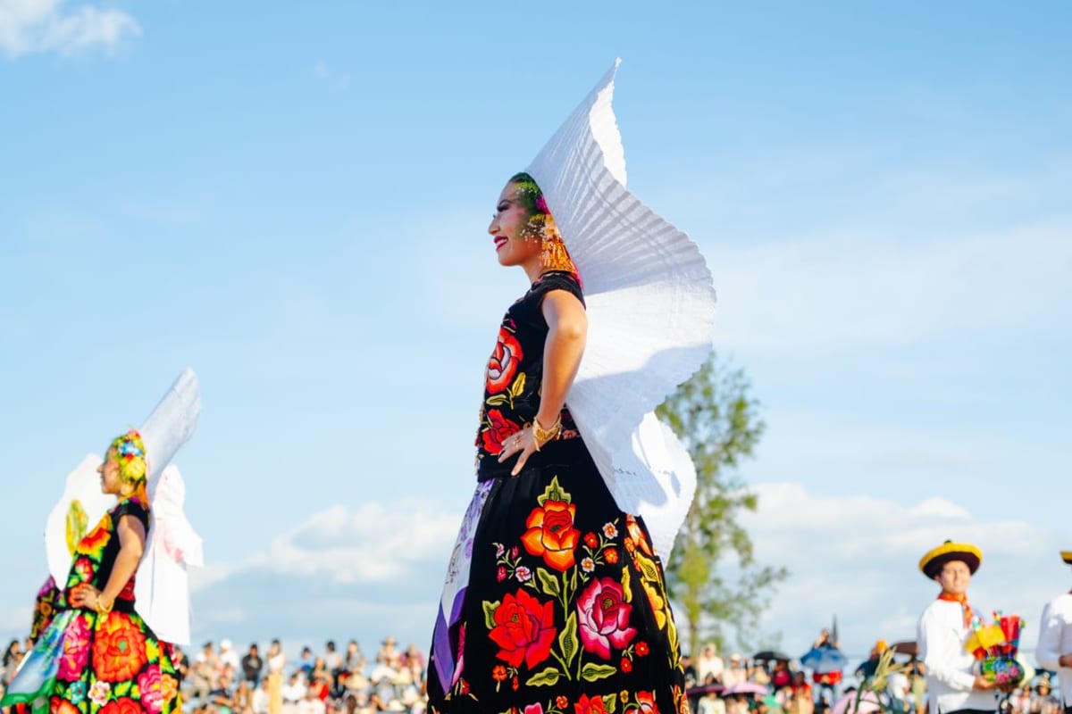 Traditioneller oaxacanischer Tanz mit farbenfrohen bestickten Kostümen und festlicher Atmosphäre während der Guelaguetza-Feierlichkeiten in Oaxaca Mexiko