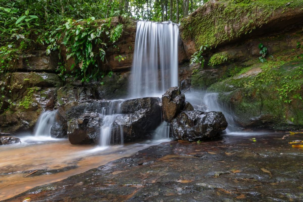 Waterfall cascading through dense jungle on a hiking trail near Puerto Escondido