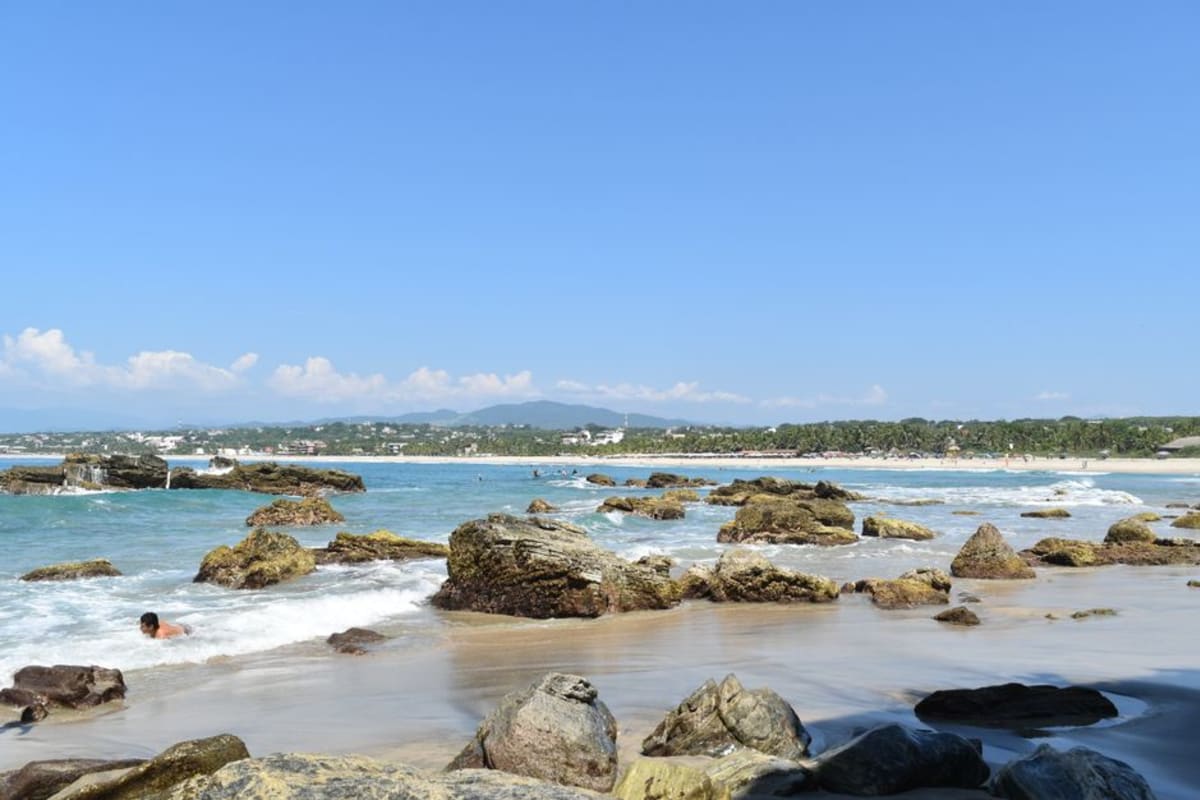 Spanish beach phrases for Puerto Escondido — stunning view of Playa Puerto Escondido Oaxaca with rocky shores and clear Pacific waves
