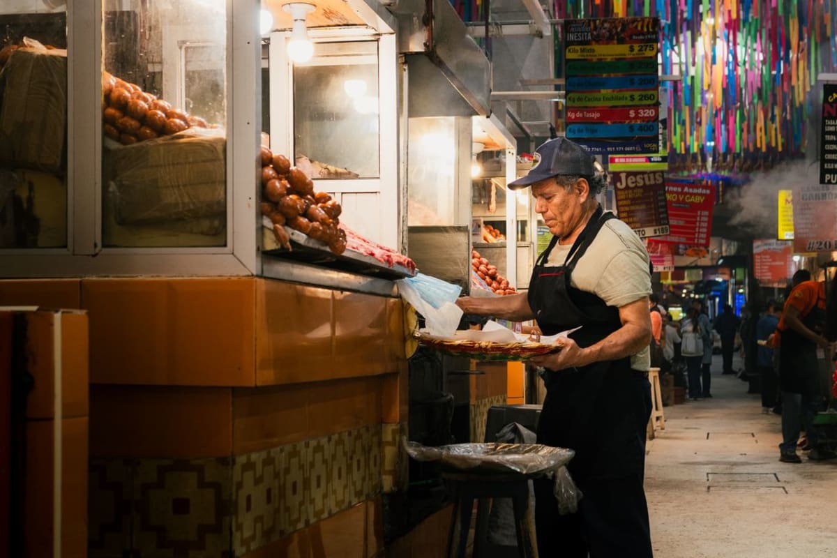 Street food vendor serving traditional Oaxacan dishes at a market in Mexico