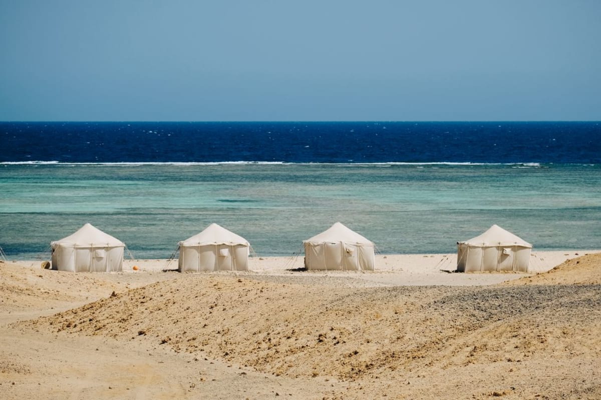Small tent shelter pitched on a quiet sandy beach near the ocean in Puerto Escondido