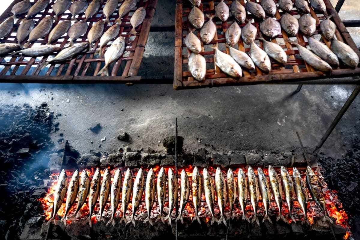 Whole fresh fish grilling over an open flame, the pescado a la talla style served at seafood restaurants in Puerto Escondido