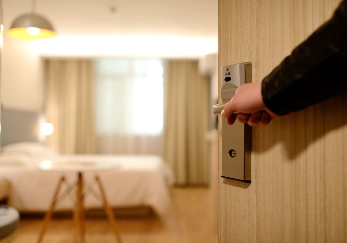 Hotelzimmer-Interieur mit großem Fenster das einen Blick auf den blauen Pazifischen Ozean und natürliches Licht einrahmt