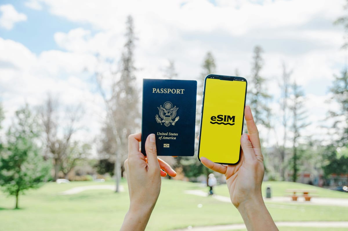 Voyageur tenant passeport et smartphone avec application eSIM — prêt à activer avant d'atterrir au Mexique