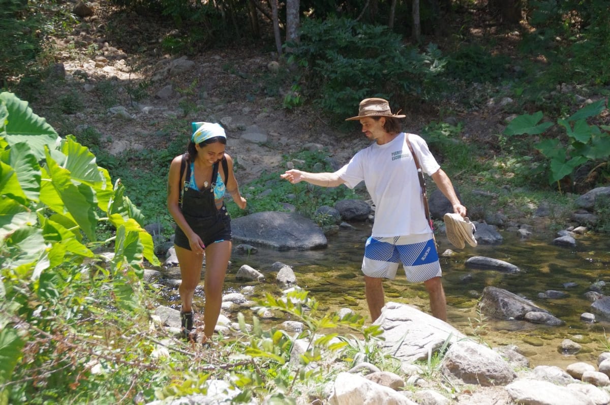 Hikers crossing a shallow river on the trail to the Atotonilco hot springs near Puerto Escondido