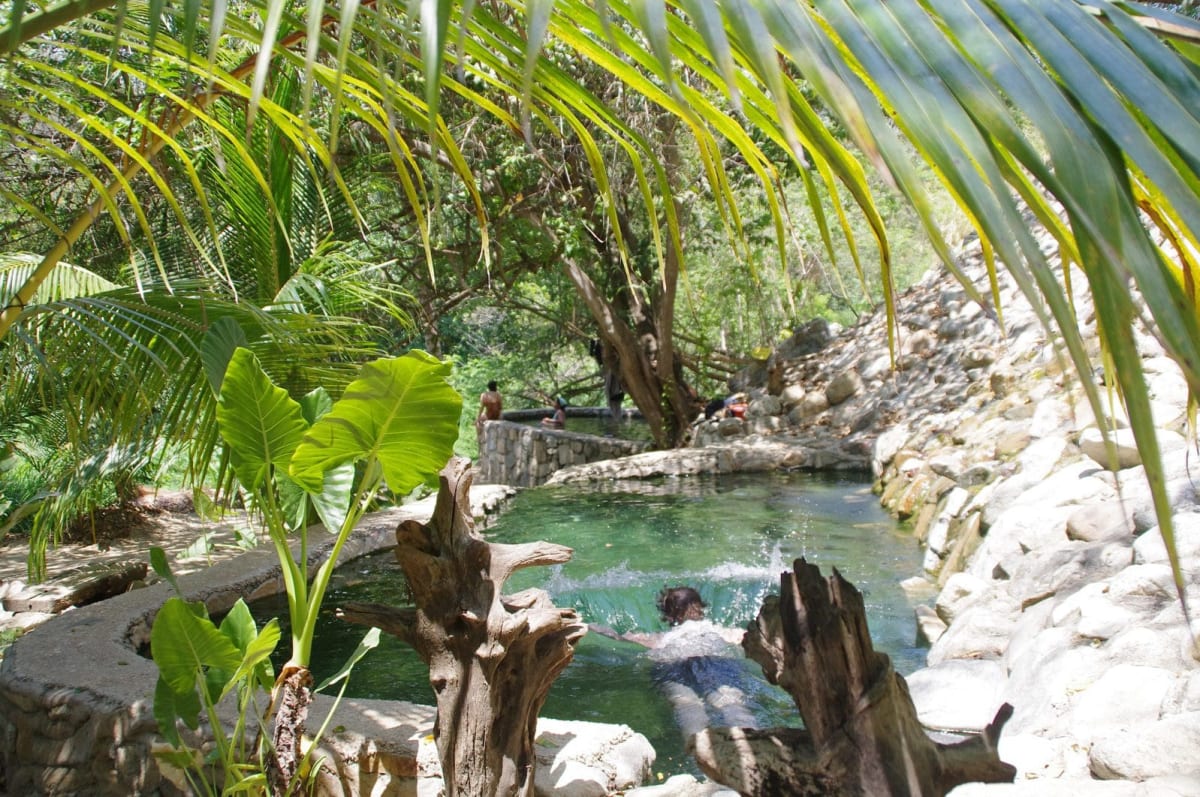 Hikers swimming in the warm mineral pools at the Atotonilco hot springs near Puerto Escondido