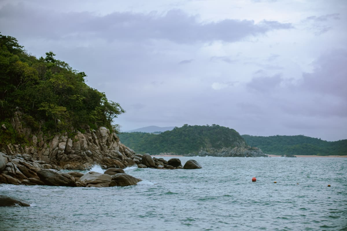 Rocky coastline and lush greenery in Santa María Huatulco, Oaxaca, Mexico.
