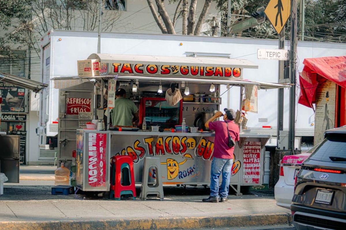 Street food vendor selling tacos in Mexico — in Puerto Escondido a full taco meal at a local stand costs under 80 pesos, making eating out cheap for expats and nomads