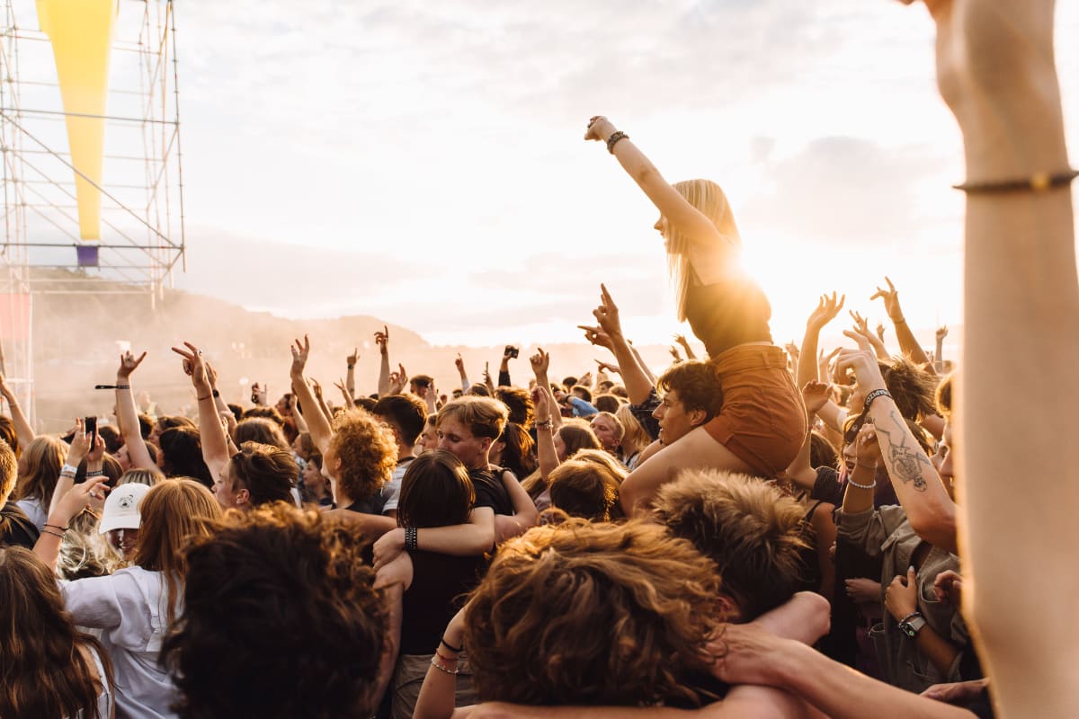 Energetic crowd enjoying live music concert at a sunset festival on the Mexican coast