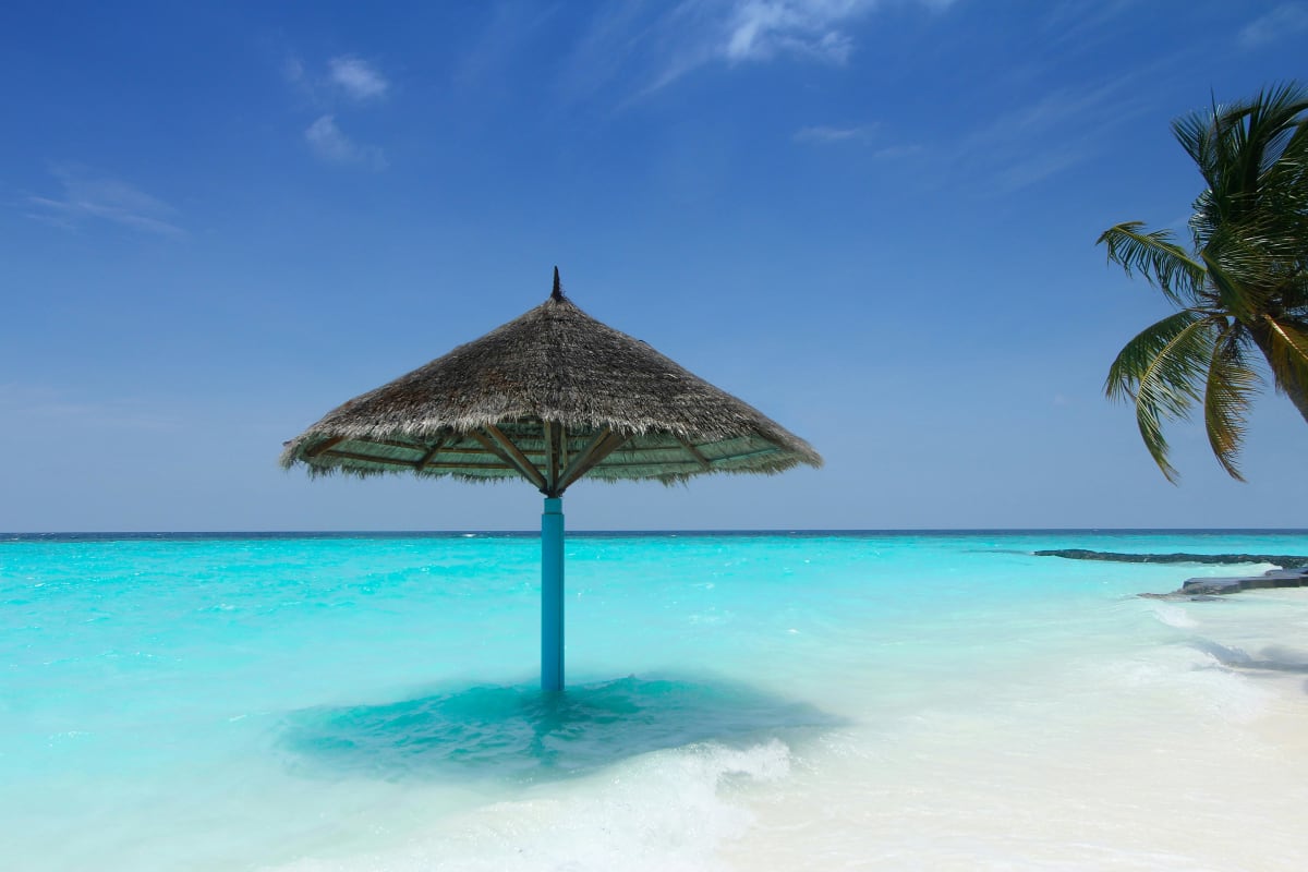Relaxing under a beach umbrella beside turquoise ocean water in Puerto Escondido, Mexico in February
