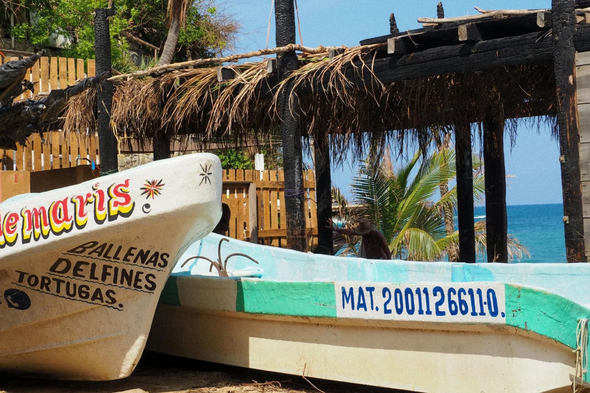 Barques de pêche colorées amarrées dans la baie principale de Puerto Escondido au lever du soleil