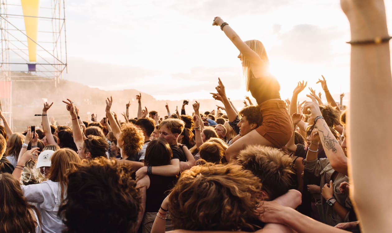 Energetic crowd enjoying live music concert at a sunset festival on the Mexican coast