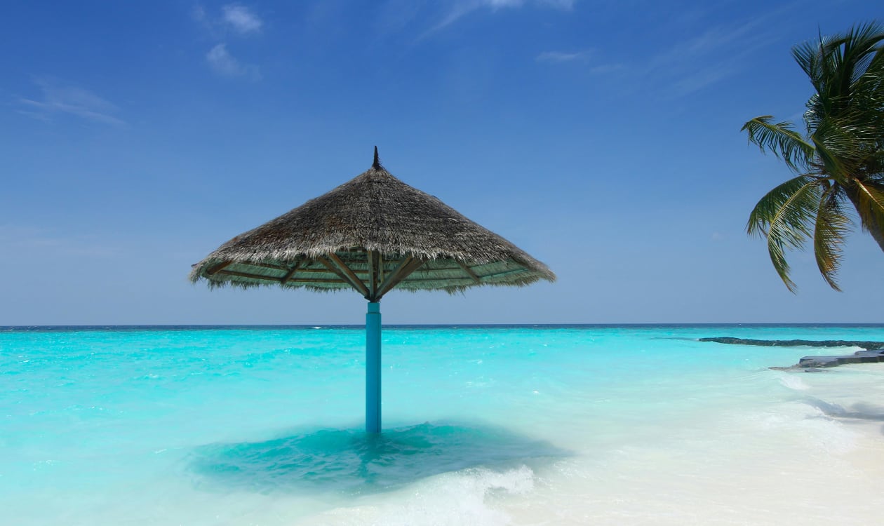 Relaxing under a beach umbrella beside turquoise ocean water in Puerto Escondido, Mexico in February