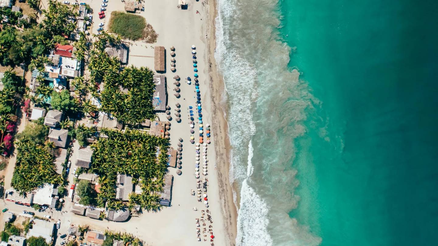 Aerial view of Puerto Escondido beach with turquoise ocean and palm trees