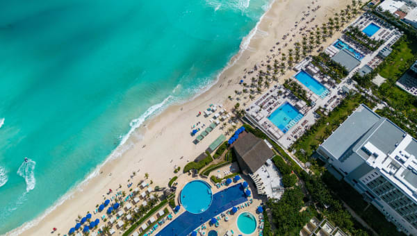 Stunning top view of a Cancun beach resort with turquoise water and sandy shore.