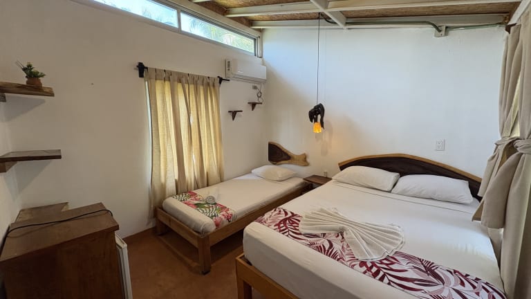 Triple room with wooden headboard and AC