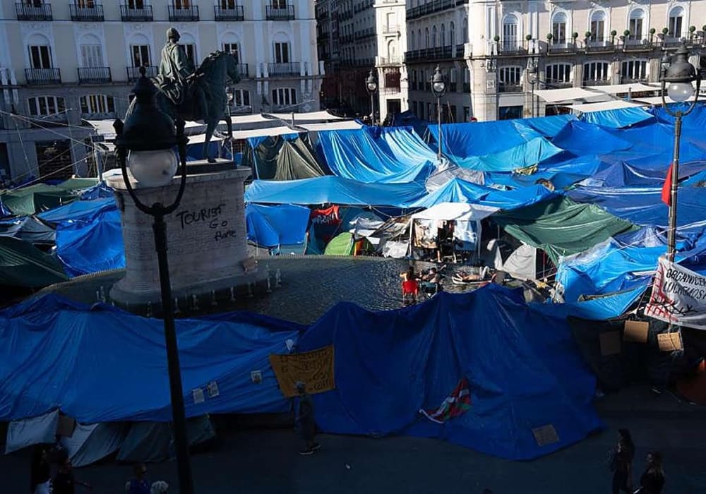 Els acampats a la Porta del Sol utilitzen la font de la plaça com a piscina i es banyen amb matalassets