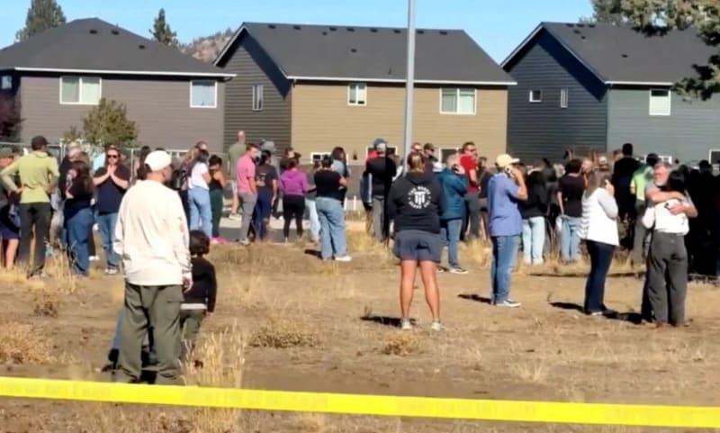 Personas permanecen cerca del lugar de un tiroteo en la escuela primaria Silver Rail, en Bend, Oregón.