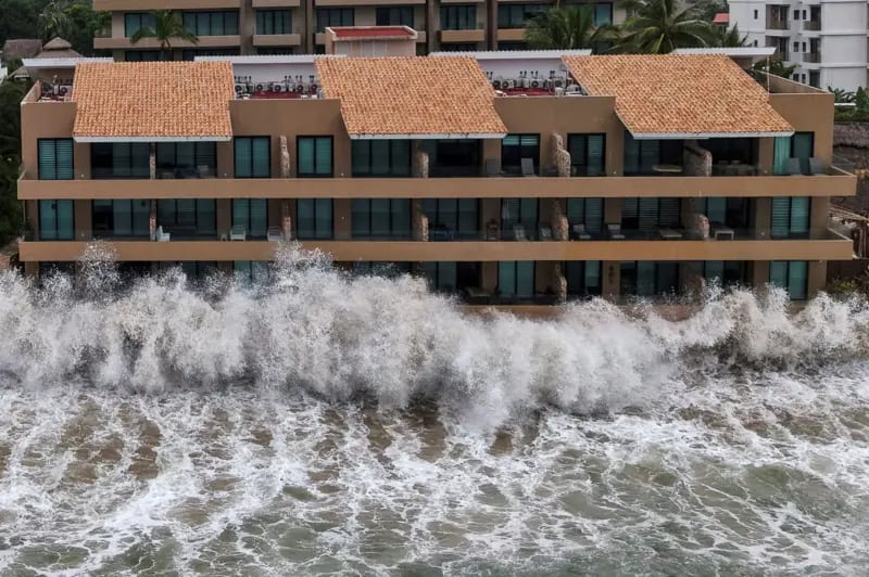 Olas rompen sobre la fachada de un hotel construido al pie de playa en Bahía de Banderas, México.