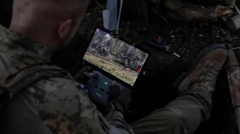Un soldado coloca un teléfono conectado a Starlink sobre su chaleco antibalas para comunicarse con otras tropas.