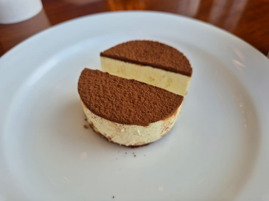 Tiramisu cut in two on a white plate