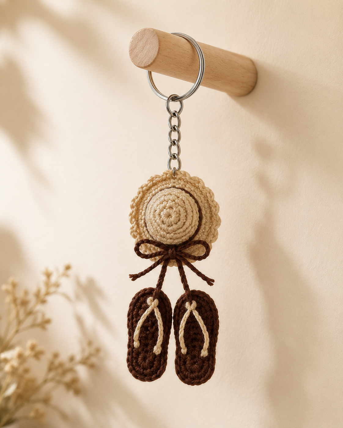 Cocoa Beach Hat & Sandals Keychain hanging on a wooden wall hook, beige hat charm with brown bow and matching brown sandals.