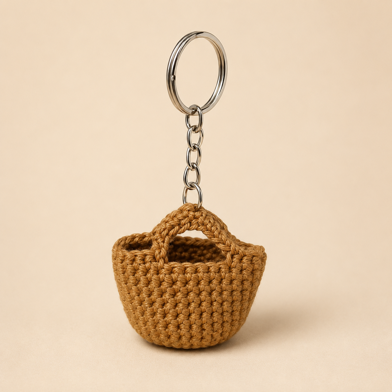 Honey Basket Keychain product photo, mini brown basket charm with metal keyring and chain on a warm plain background.