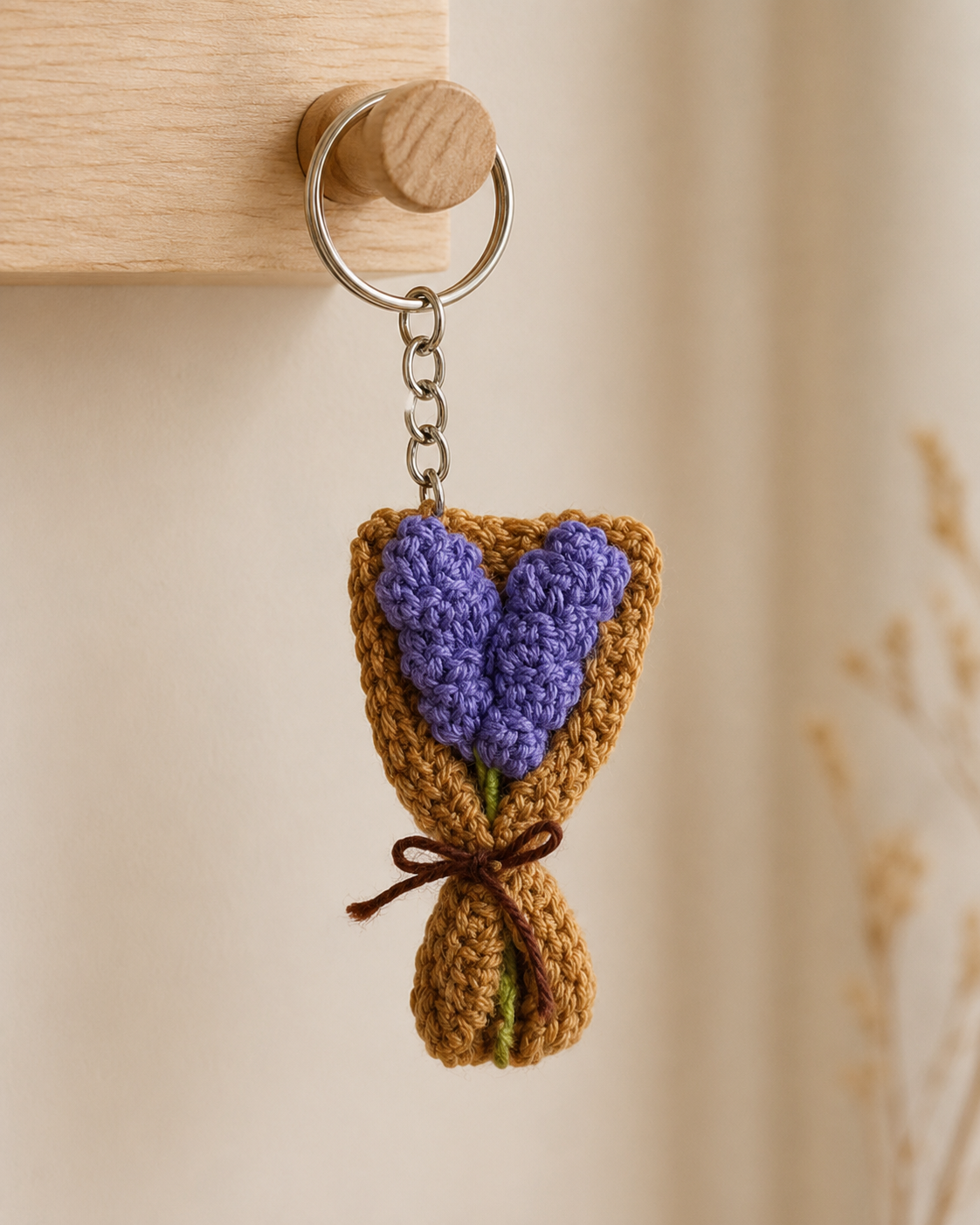 Lavender Bouquet Keychain hanging from a cream handbag, purple lavender flowers with brown bouquet wrap and metal keyring.