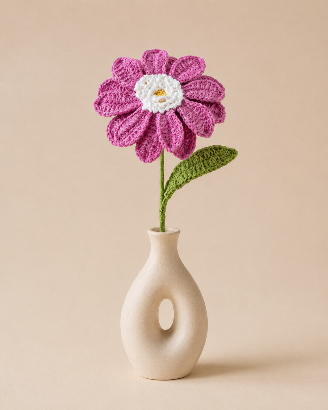 Magenta Meadow African Daisy Stem displayed in a modern beige vase on a plain neutral background.