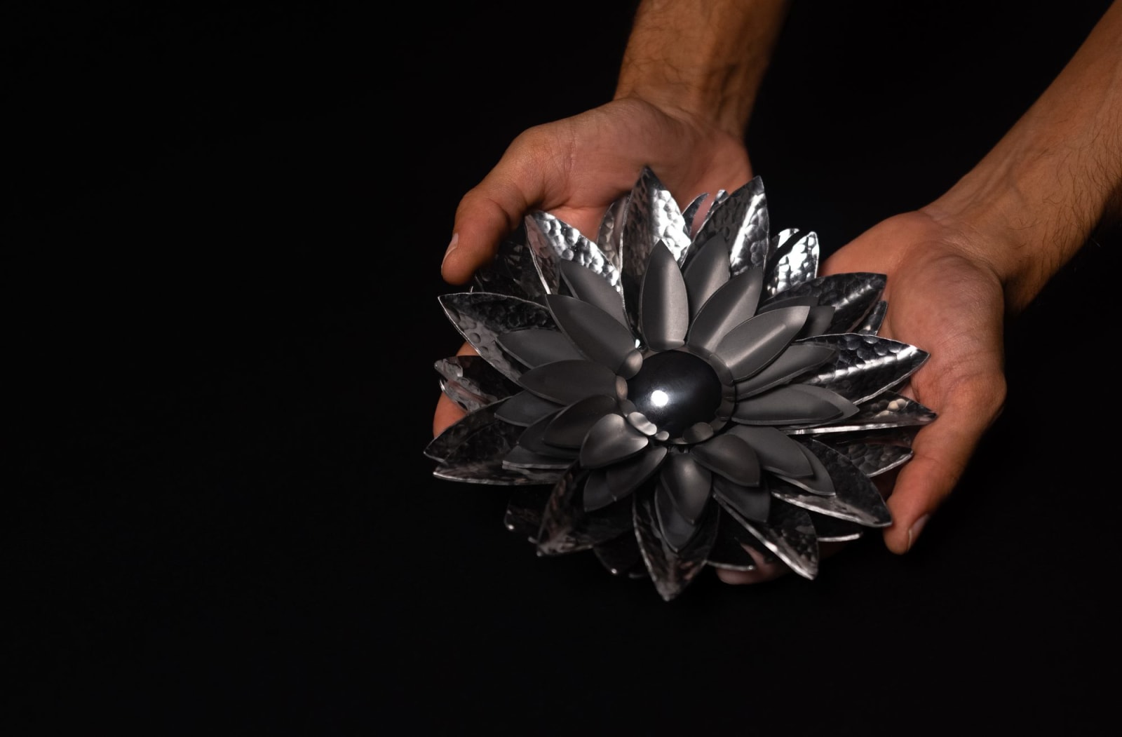 Hands holding Bloom sculpture