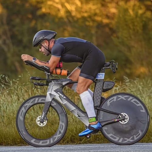 Atleta Axion Cycle pedalando em alta performance com roda Disc Brake