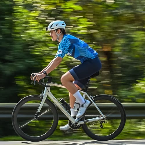 Atleta Axion Cycle pedalando em alta performance com roda Rim Brake