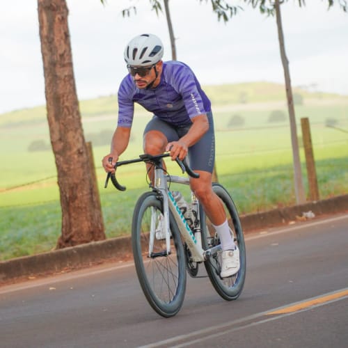 Atleta Axion Cycle pedalando em alta performance com roda Rim Brake