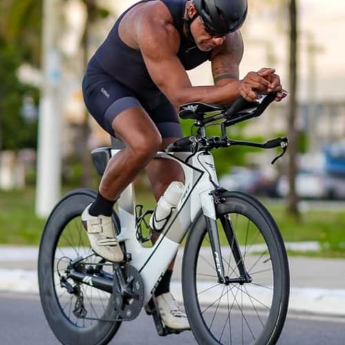 Atleta Axion Cycle pedalando em alta performance com roda Rim Brake