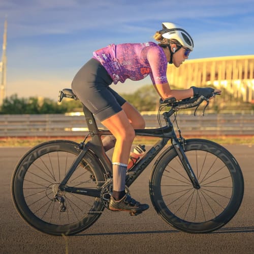 Atleta Axion Cycle pedalando em alta performance com roda Rim Brake