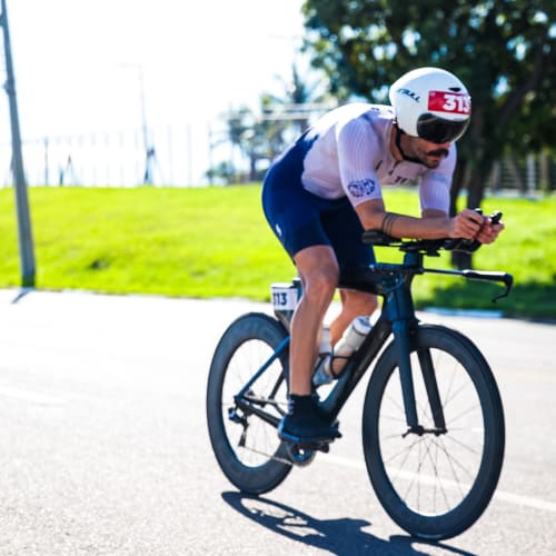 Atleta Axion Cycle pedalando em alta performance com roda Rim Brake
