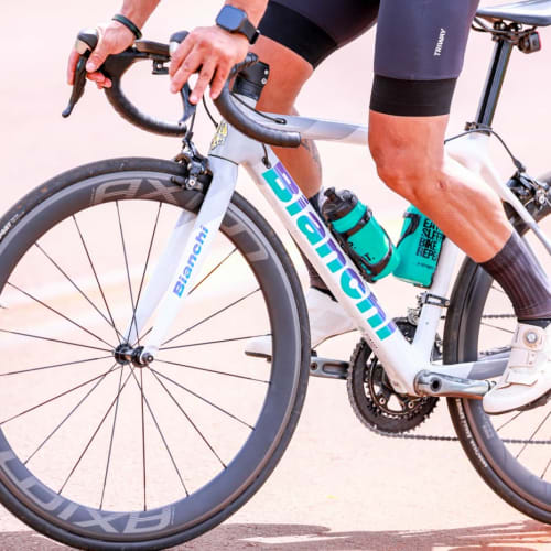 Atleta Axion Cycle pedalando em alta performance com roda Rim Brake