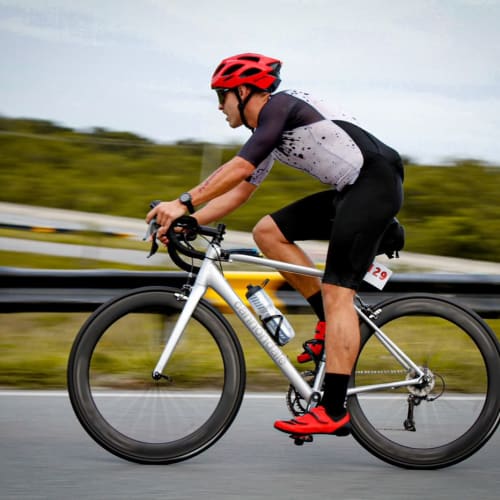 Ciclista profissional em treino com roda de carbono Rim Brake Axion Cycle
