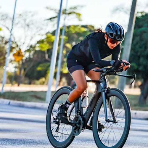 Atleta Axion Cycle pedalando em alta performance com roda Rim Brake