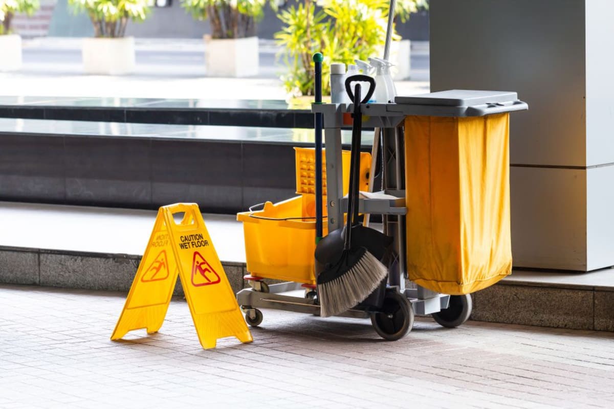 Janitorial mop bucket cart in a clean commercial hallway.
