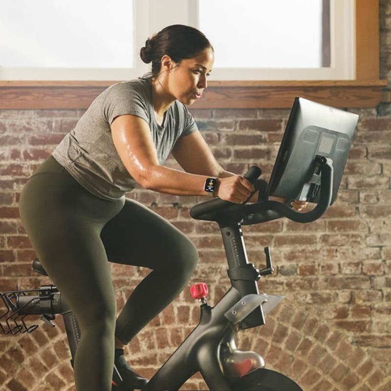 Mujer entrenando con reloj inteligente Amazfit Bip 6 en bicicleta