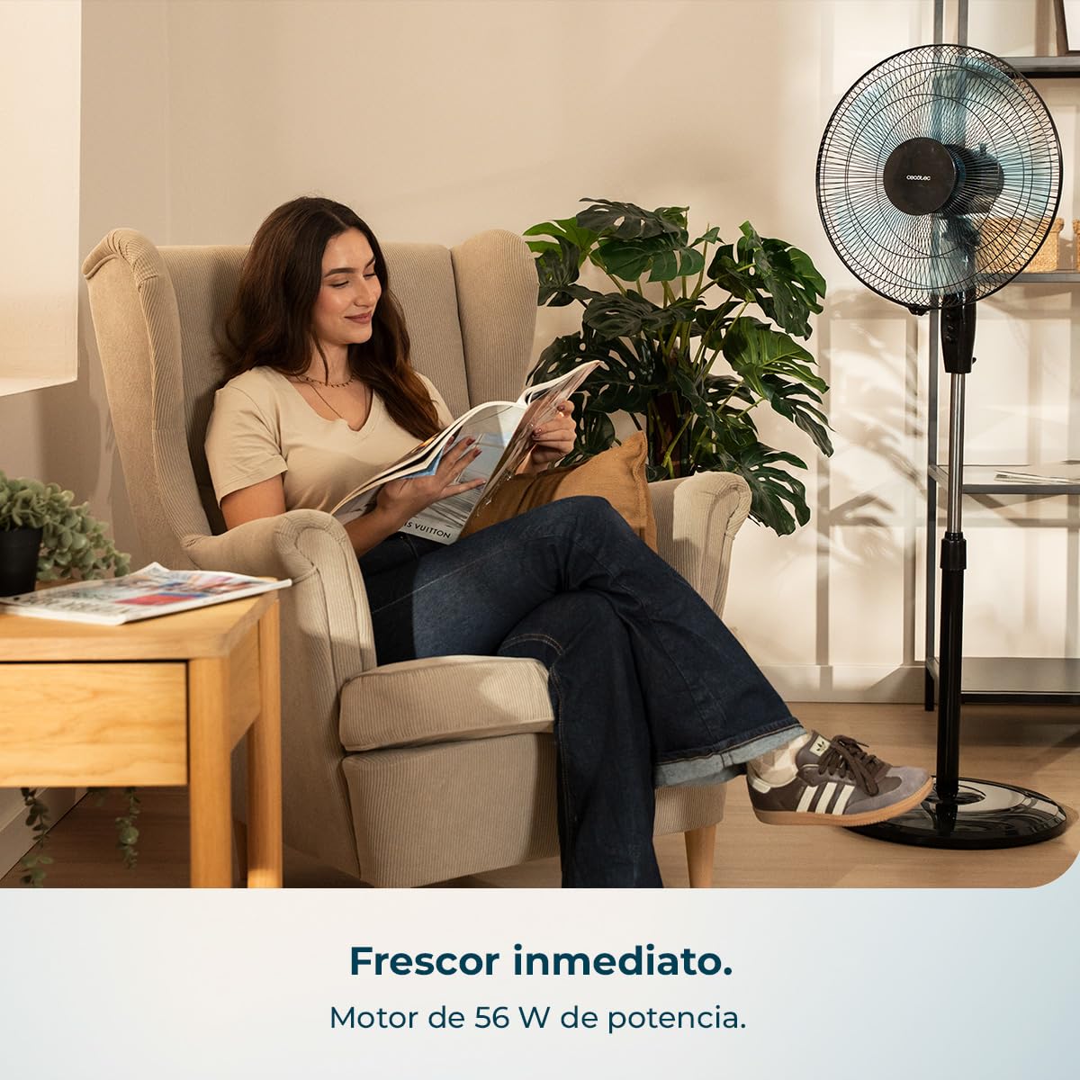 Mujer relajada leyendo junto a ventilador de pie Cecotec EnergySilence 515 negro en salón moderno