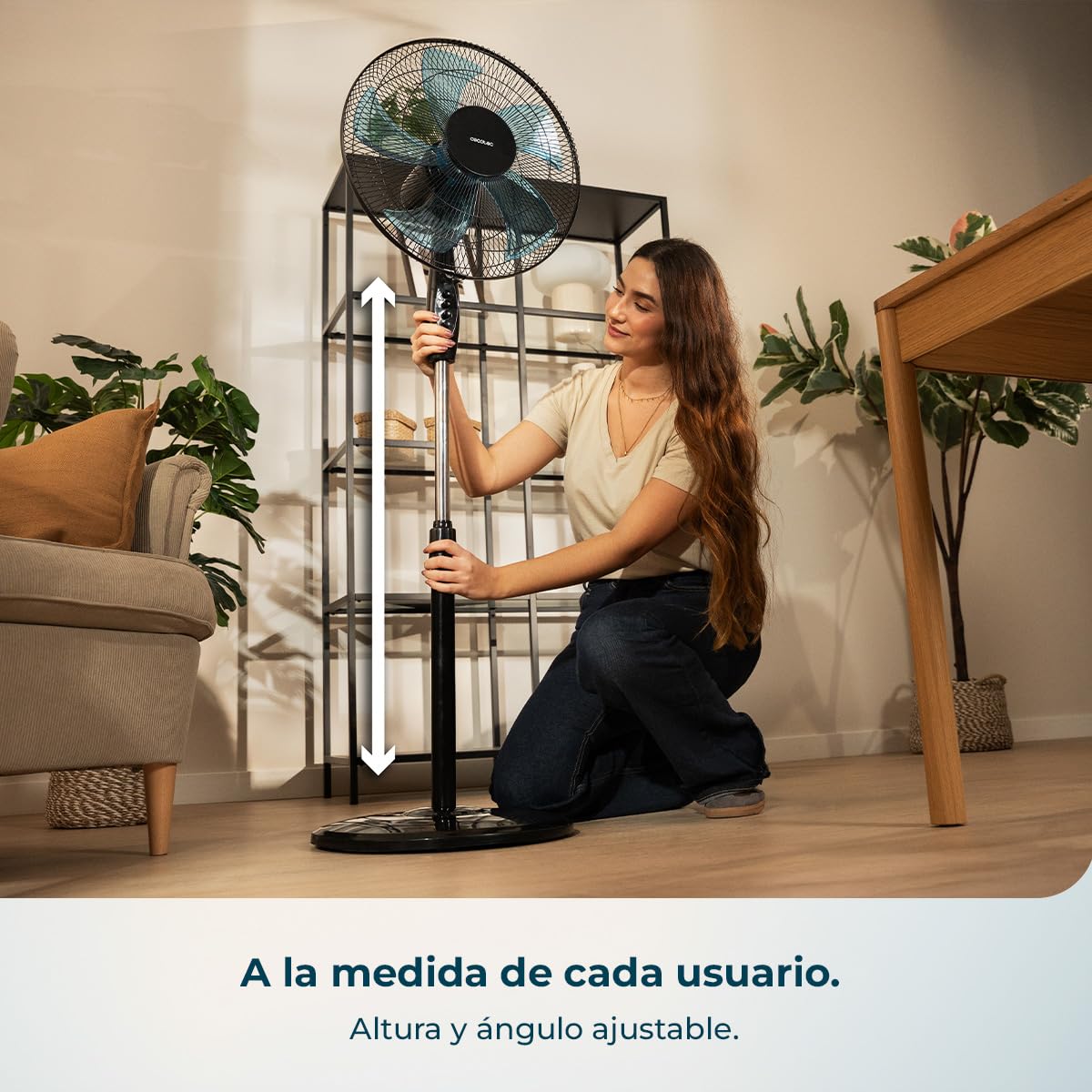 Mujer ajustando la altura del ventilador de pie Cecotec EnergySilence 515 negro en un salón moderno