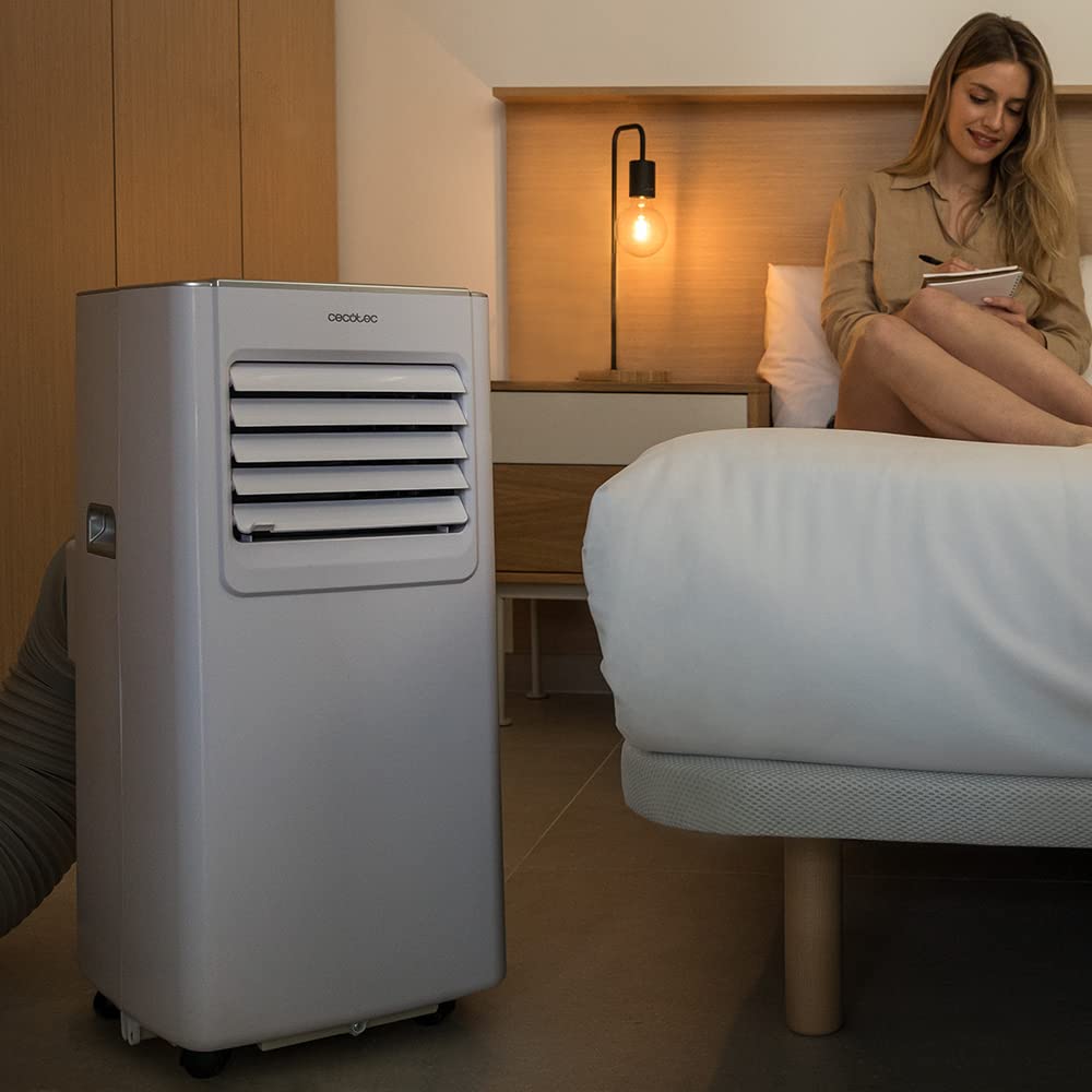 Aire acondicionado portátil Cecotec ForceClima 7100 en dormitorio moderno junto a cama con mujer